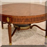 F16. Maitland Smith round mahogany and brass banded coffee table. Some small chips to finish. 17.5”h x 36”w - $750 
